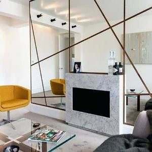 Sala de estar com lareira e espelho de parede inteira moderno com mesa de centro de vidro