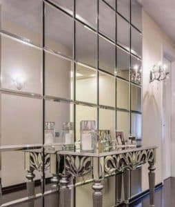 Hall de entrada com aparador e espelho de parede com bisotê quadrados