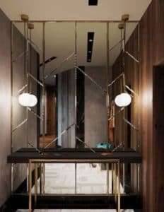 Hall de entrada com aparador inox dourado e parede espelhada.