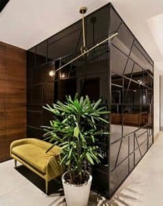 Hall de entrada com parede arquitetônica revestida de espelho preto